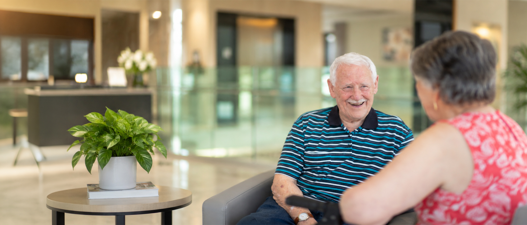 Oxa Care resident smiling while chatting with another resident.