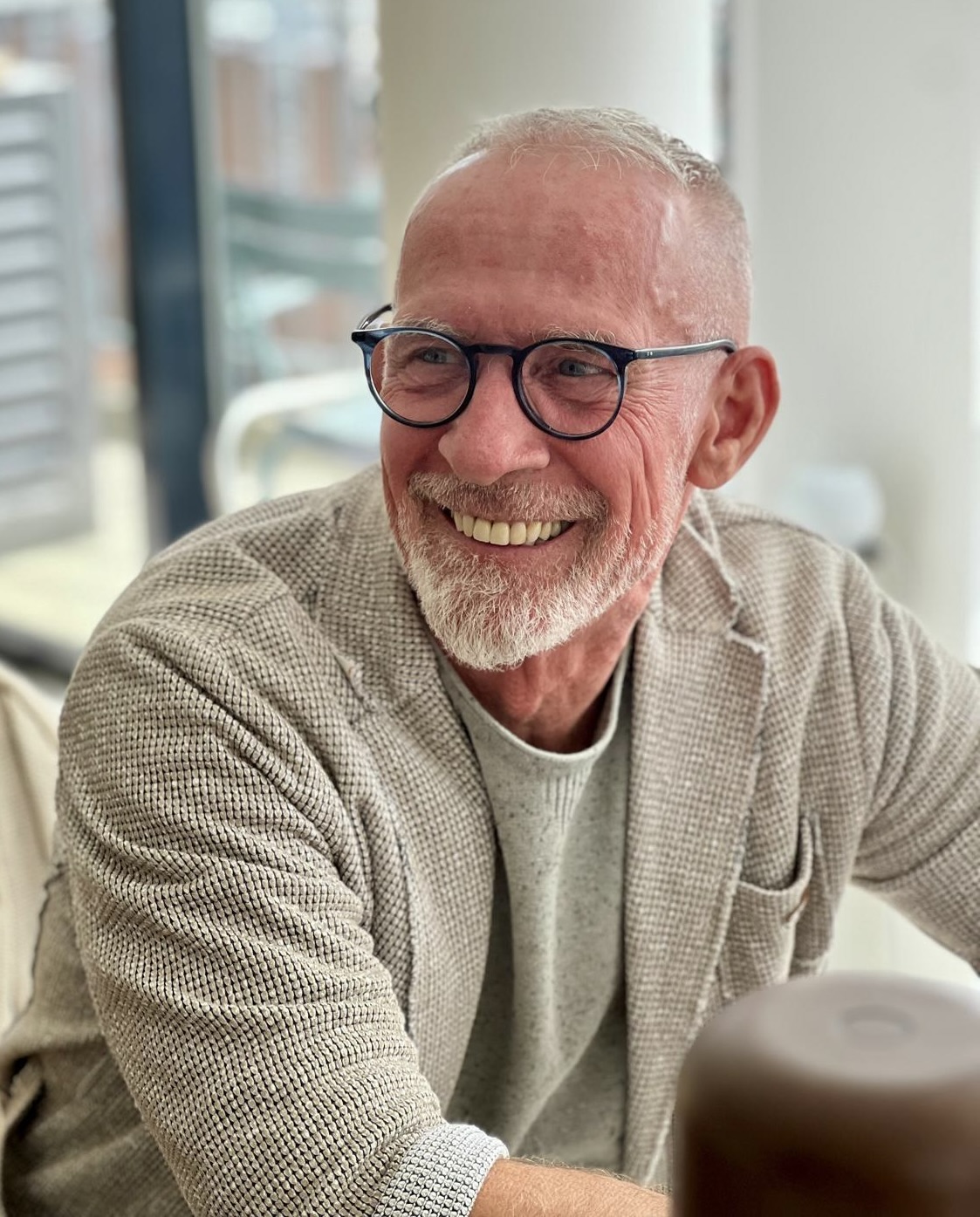 A smiling man with boats in the background