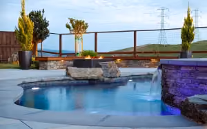This backyard contains a dipping pool with a firepit and additional stone and epi wood seating.