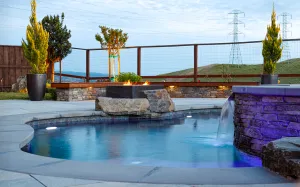 This backyard contains a dipping pool with a firepit and additional stone and epi wood seating.