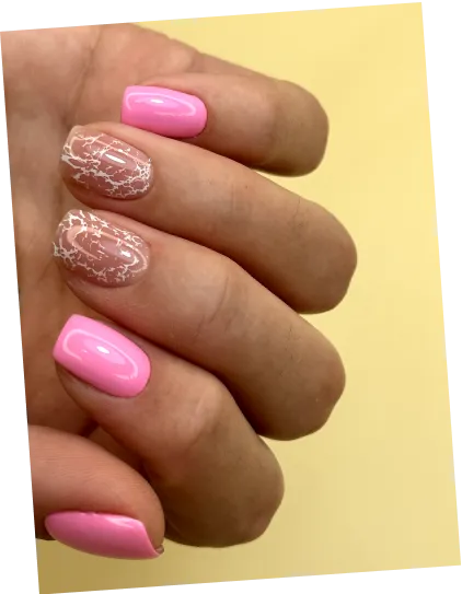 Hand with pink and transparent nails featuring white intricate patterns on a pale yellow background.