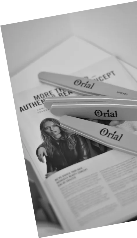 Three Orial branded nail files placed on a magazine page featuring a woman in a leather jacket.