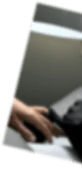 Blurred close-up of a hand playing a piano keyboard under light.
