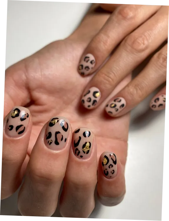 Hand with long, square-shaped nails painted in pale pink with small, silver rhinestones near cuticles.