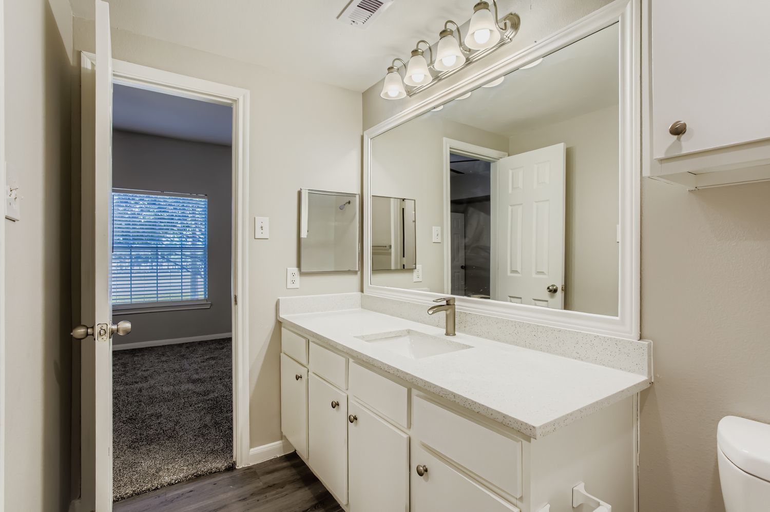 Bathroom with sink vanity and view into bedroom