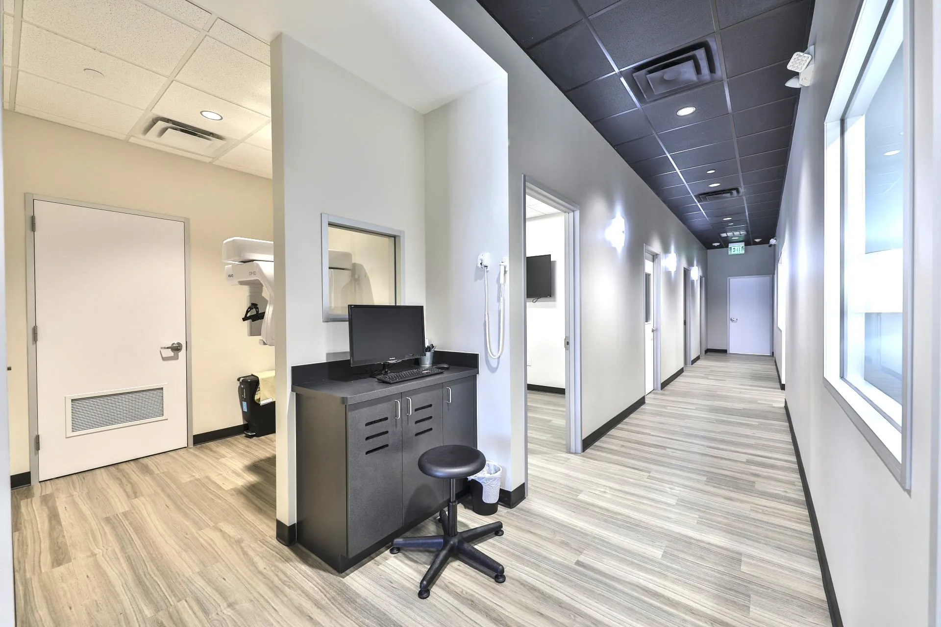 Clinical corridor with a built-in charting workstation outside the exam rooms