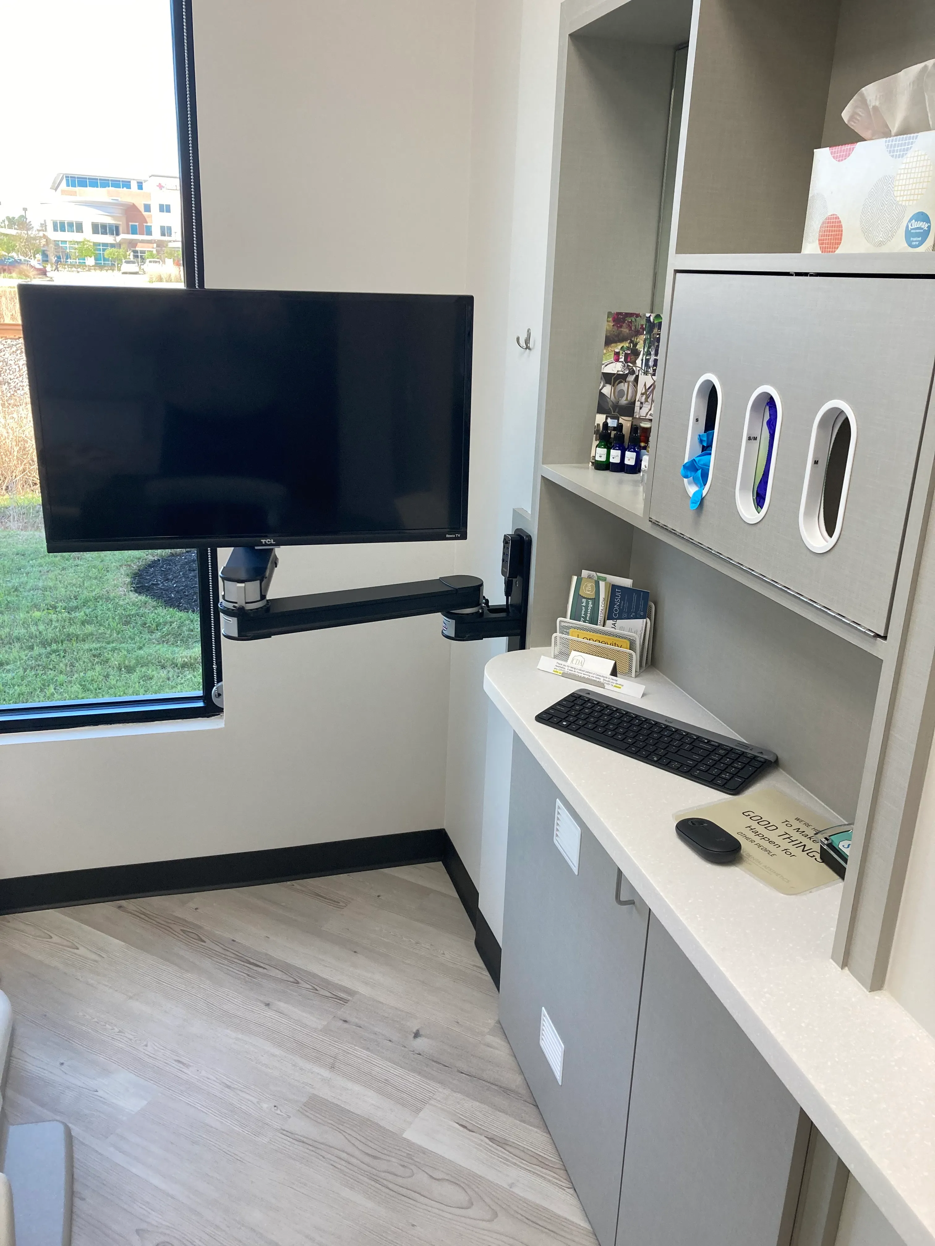 Chairside workstation on an articulating wall arm with a monitor and keyboard in a treatment room