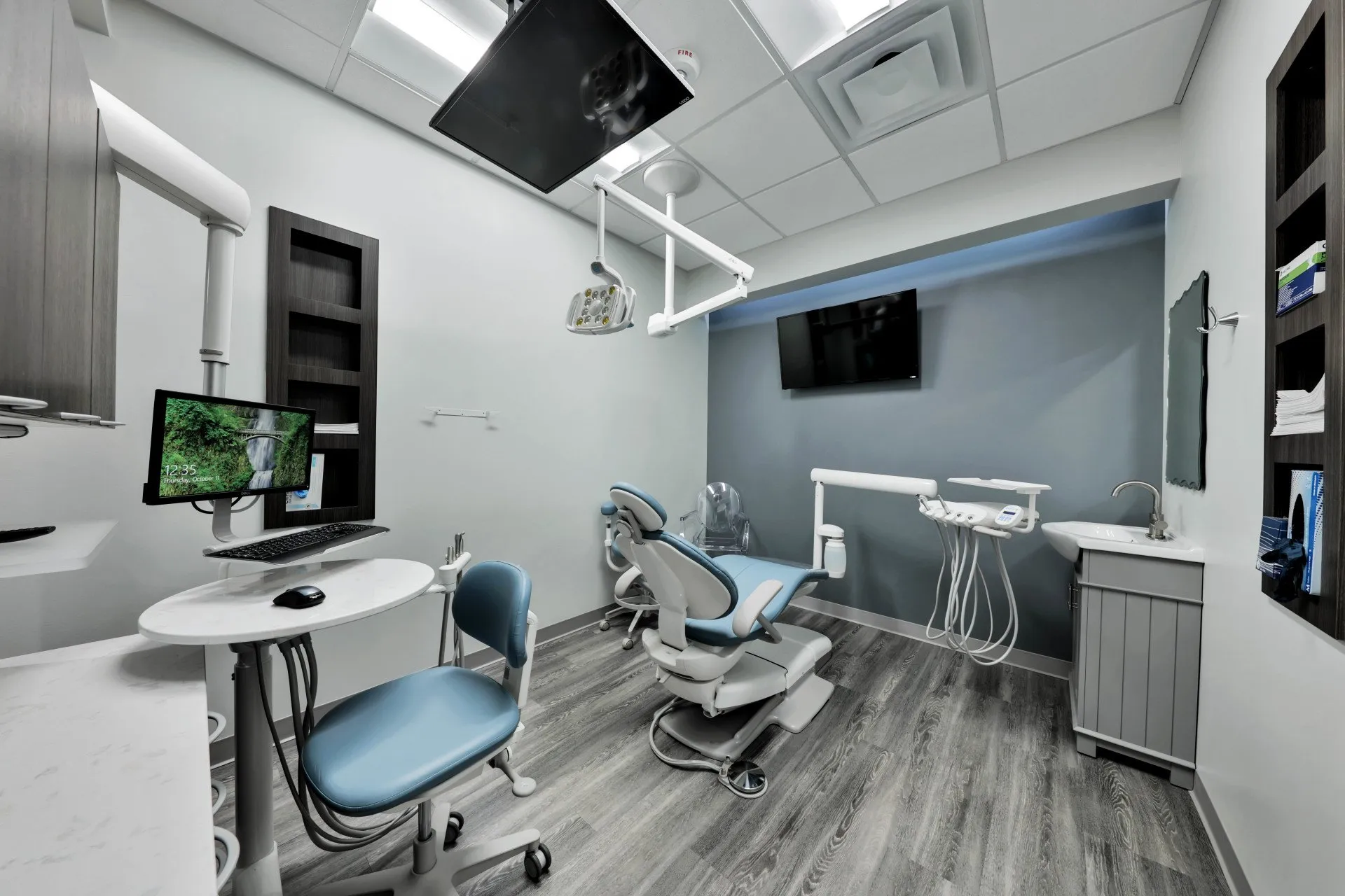 Operatory with a wall-mounted display, chairside monitor, and imaging equipment in daily use