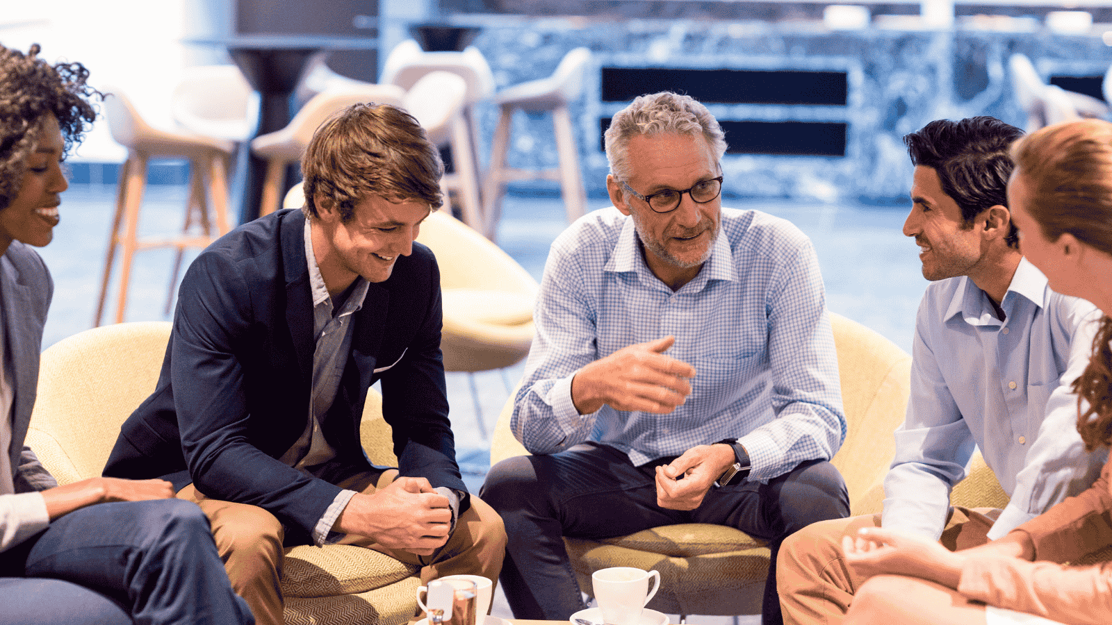 Business team engaged in an informal discussion, illustrating leadership strategies that foster growth through empowerment and trust.