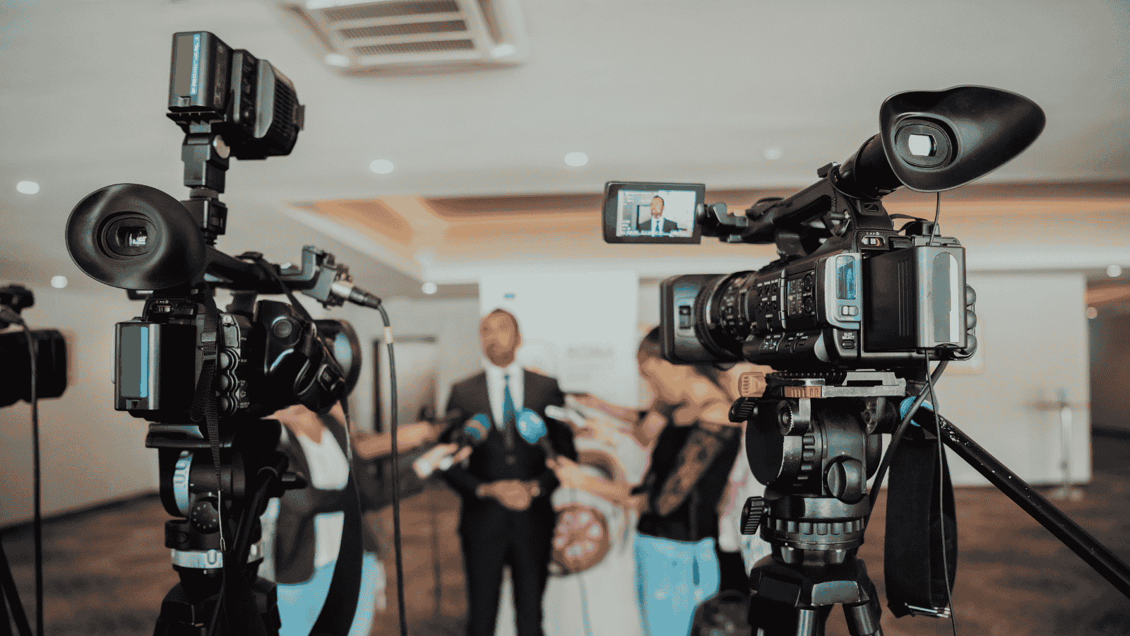 Press conference with business leader answering media questions, symbolizing how strategic PR builds visibility and credibility for B2B growth.
