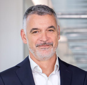 A picture of a Alessandro Faorlin, a ValueSelling Managing Partner, in a suit in a modern office. 