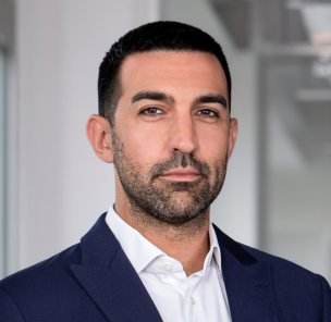 A picture of aRiccardo Pavanato, a ValueSelling Managing Partner, in a blue suit in a modern office.
