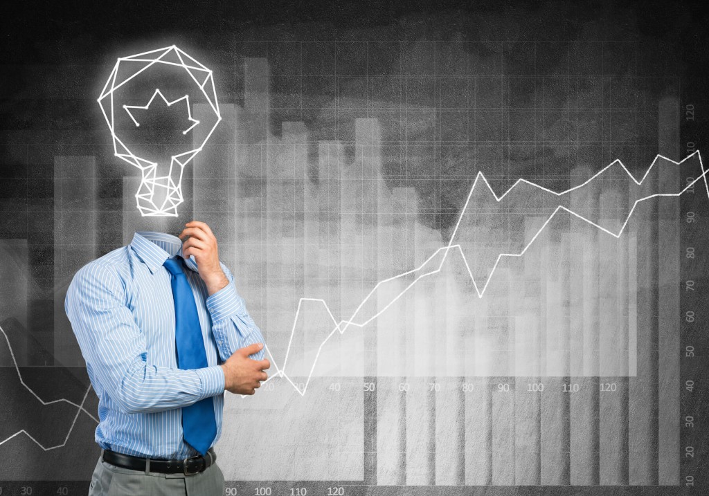 A business man with a lightbulb for a head, standing against a bar chart.