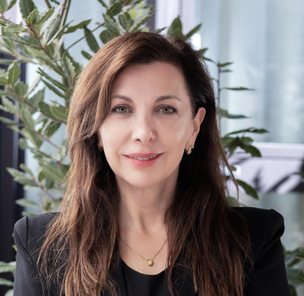 A headshot of Rosana Fernandes weaing a black suit.