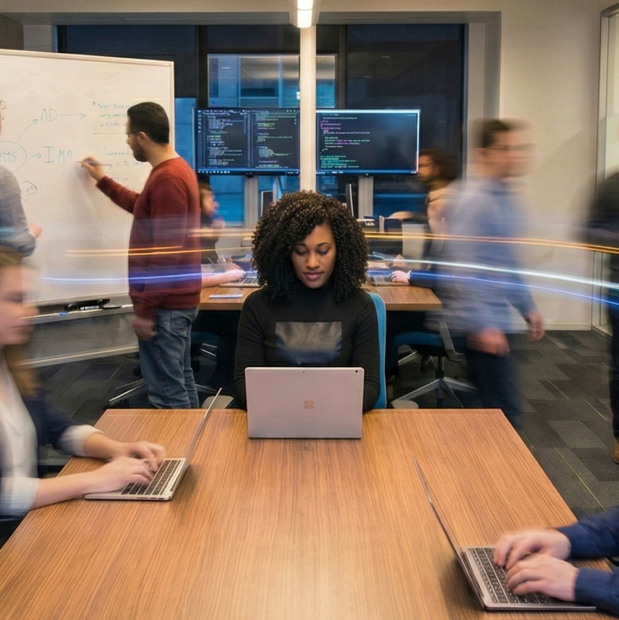 A business woman focuses on her work in the midst of a bustling workplace