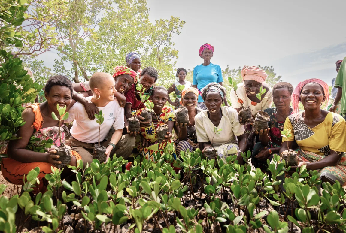 SeaTrees planting team holding mangrove seedlings in Kenya