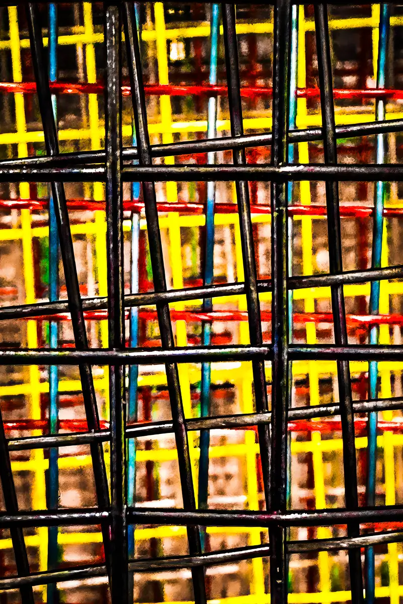 close up of multiple tennis racquet strings of different colors to form abstract pattern