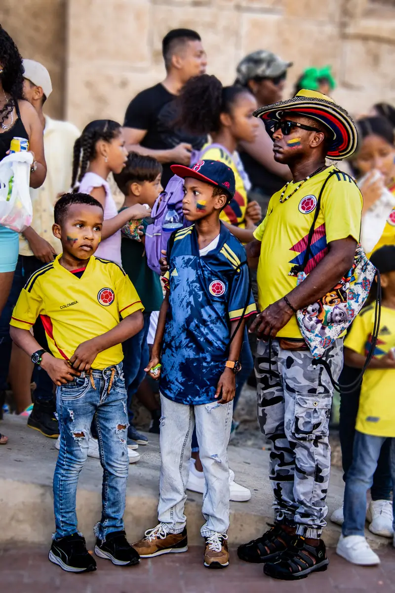 Colombia Independence Day Parade: family watching in soccer shirts