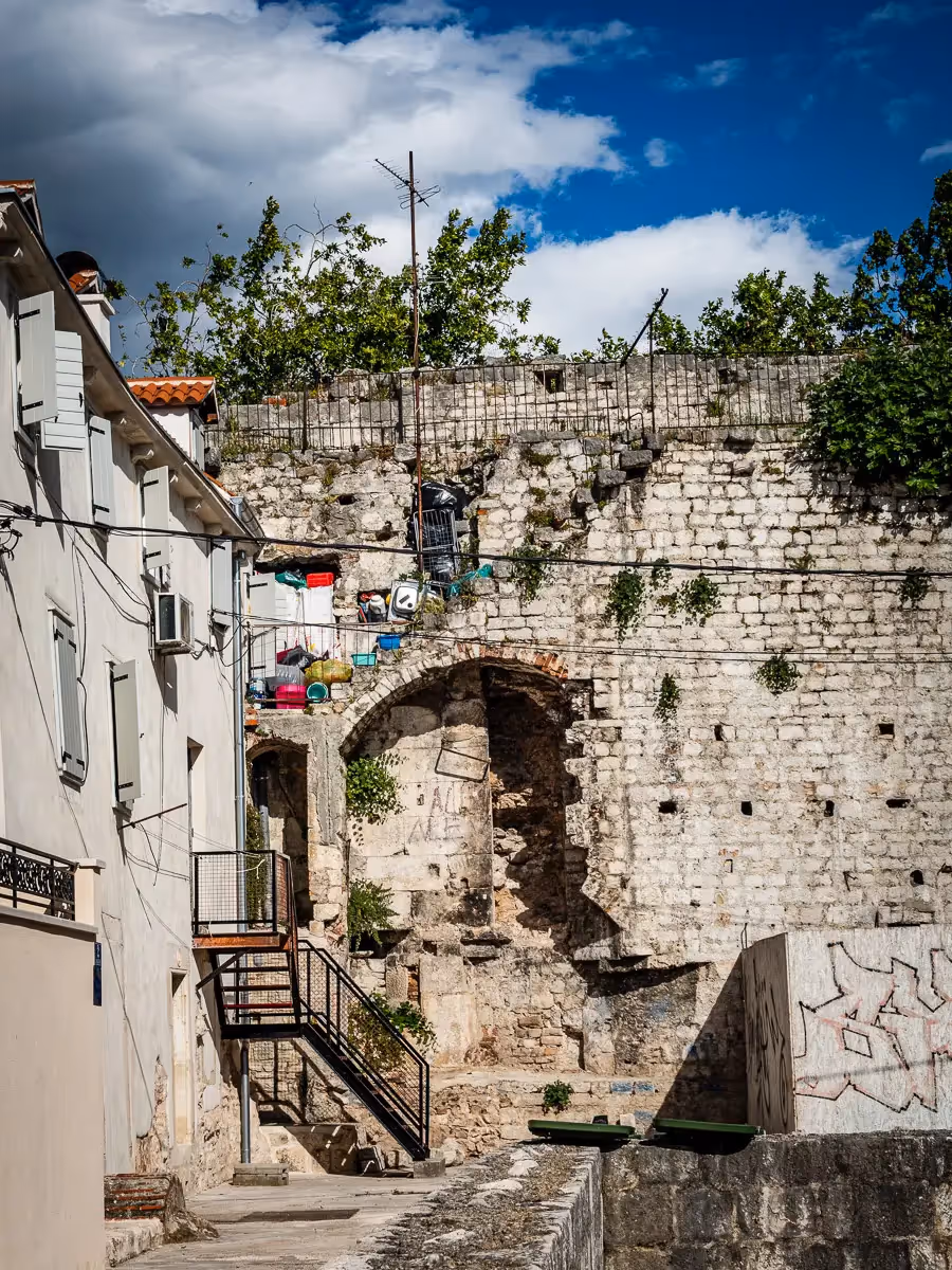 Croatia: Old stone backyard with a stairway filled with colorful plastic jugs