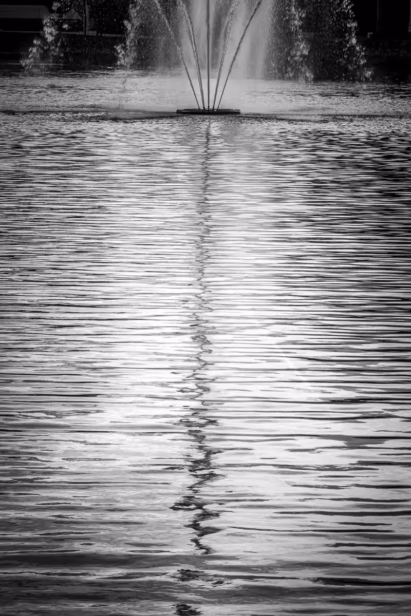Reflection of a fountain in the water of a pond
