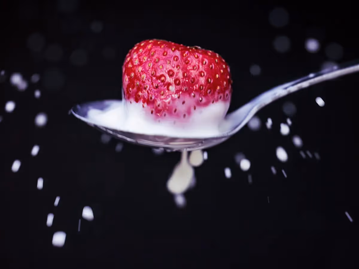 milk splatter in spoon from splashing strawberry