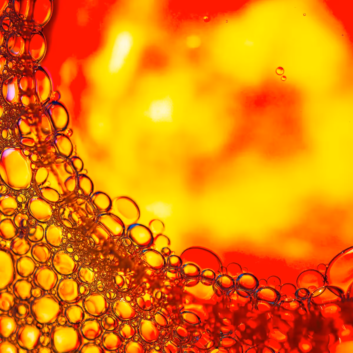 Immiscible: abstract of oil and water with a colorful background.  Red and yellow. small drops
