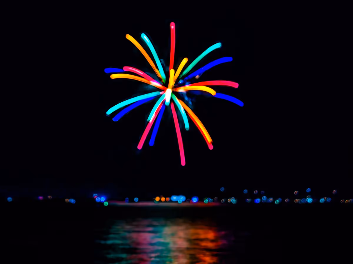 Abstract fireworks: color burst over its own reflection in the water