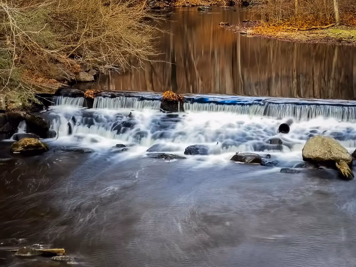 Fall stream with reflection of trees in water