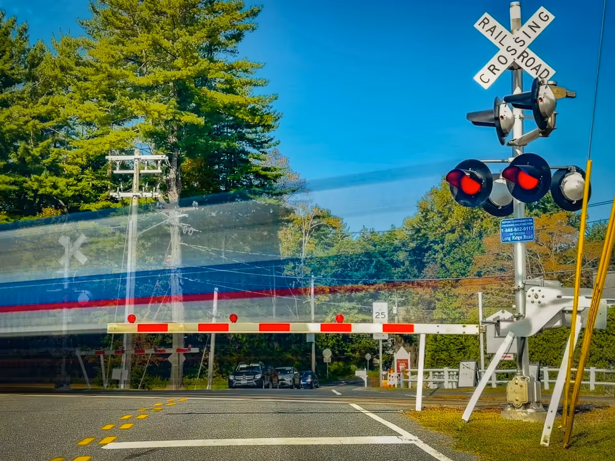 Blurred passing train while cars wait for it to pass