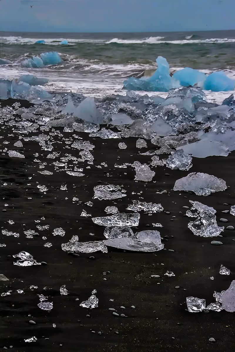 Diamond Beach in Iceland, with the black sand with scattered white and blue ice chunks  of various sizes