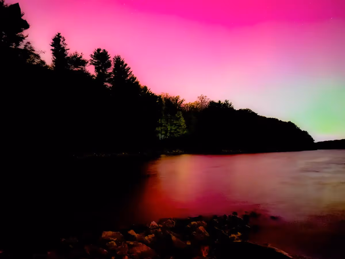Aurora Borealis of pink and green over Reservoir in Weston, CT