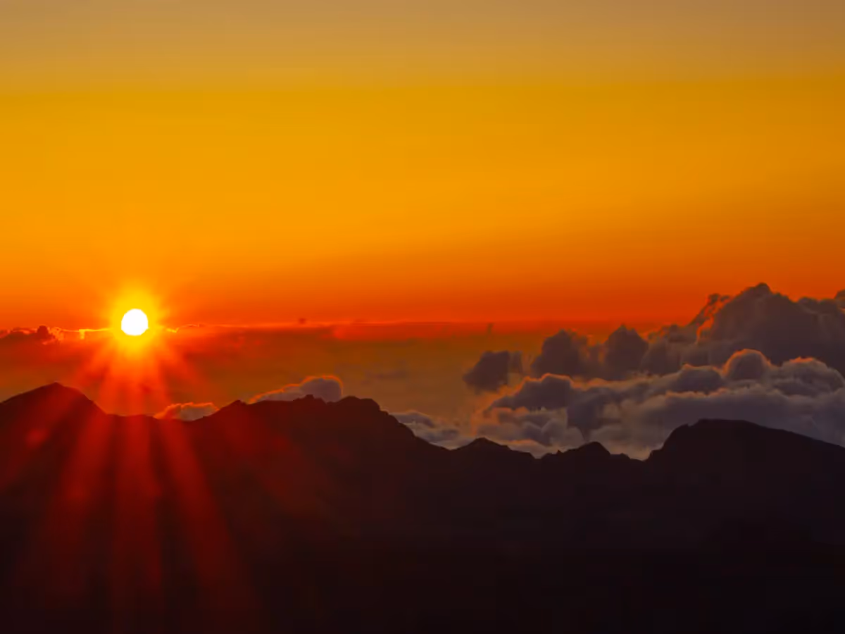 Above the clouds during sunrise on the top of Haleakala volcano in Hawaii with the sun coming up