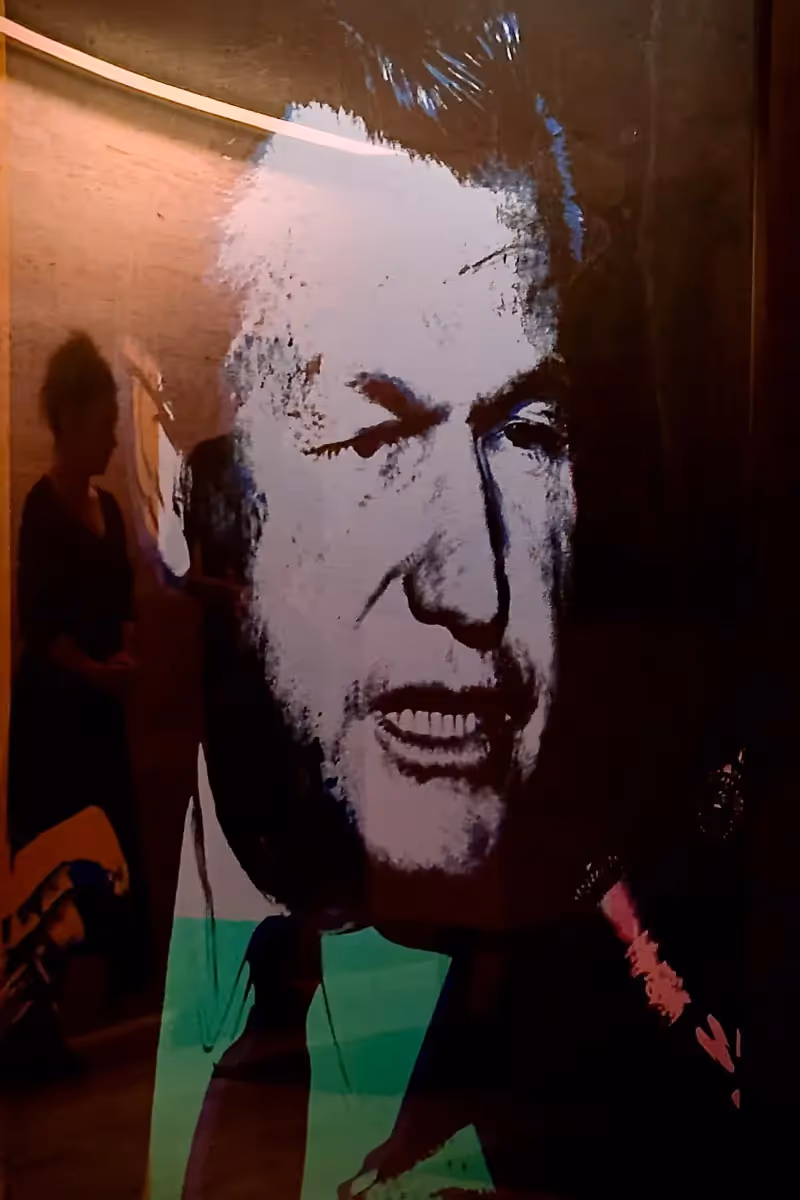 Poster of a man with the reflection of another person in the background