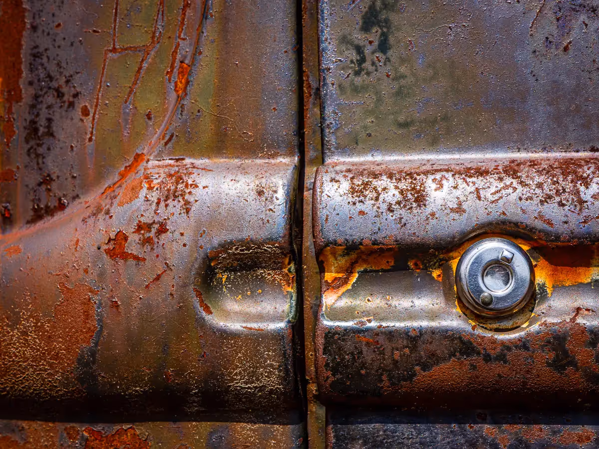 Norwalk, CT car show: crease of the door  and keyhole of an old and rusted car