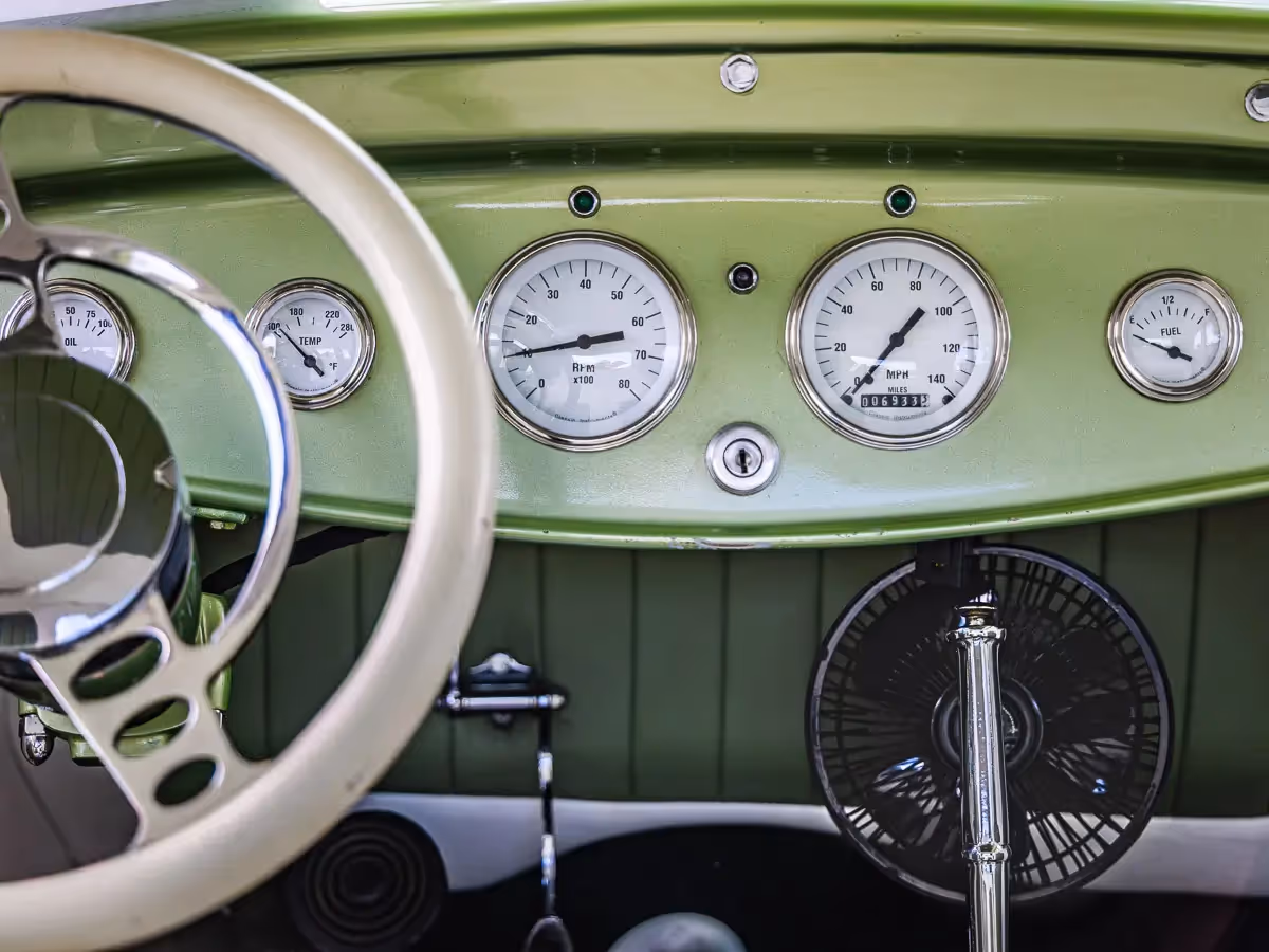 Norwalk, CT car show:  inside view of the dash and steering wheel of an old fashion, green car
