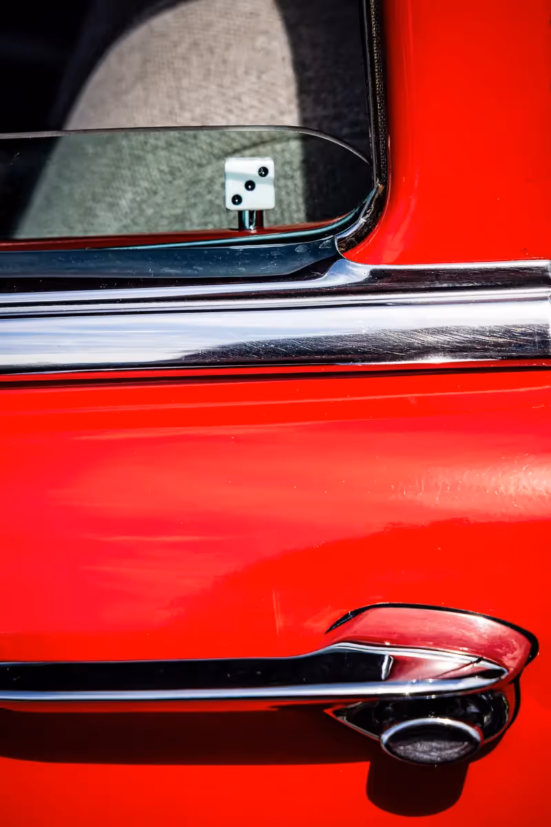 Norwalk, CT car show: door handle and a single die as the lock inside an open window of a bright red car