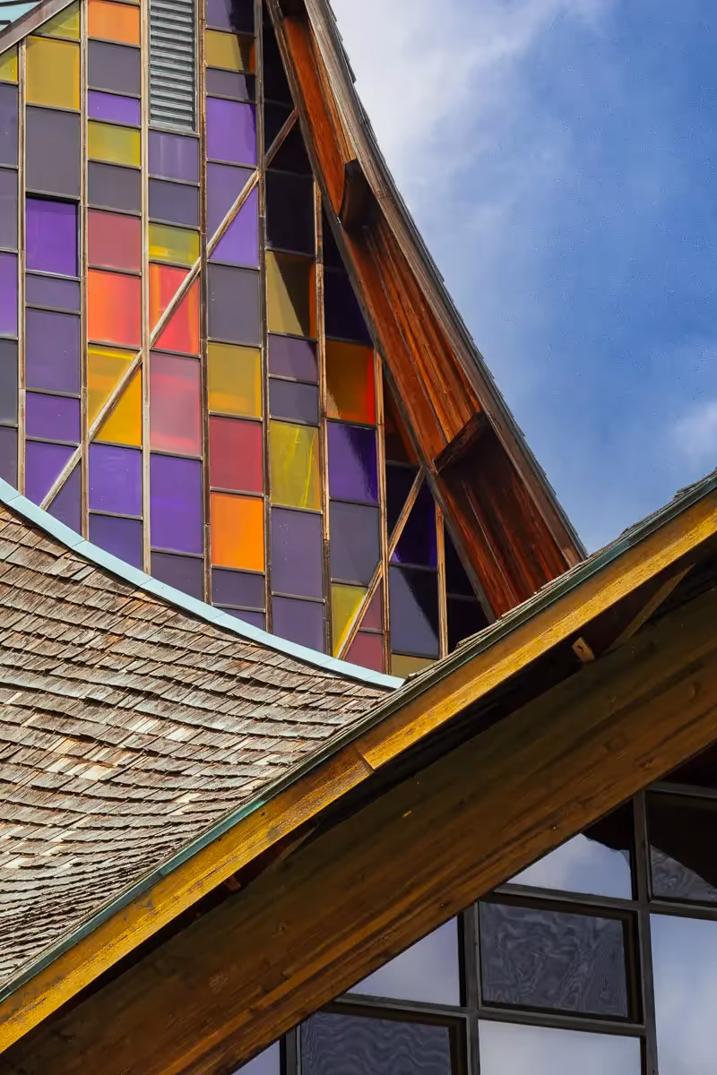 Close up of the patterns of a church with stained glass windows and shingle overhang showing different angles and colors