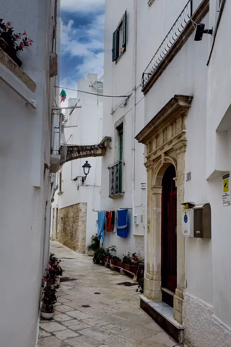 Italian quaint street with flower pots and hanging laundry
