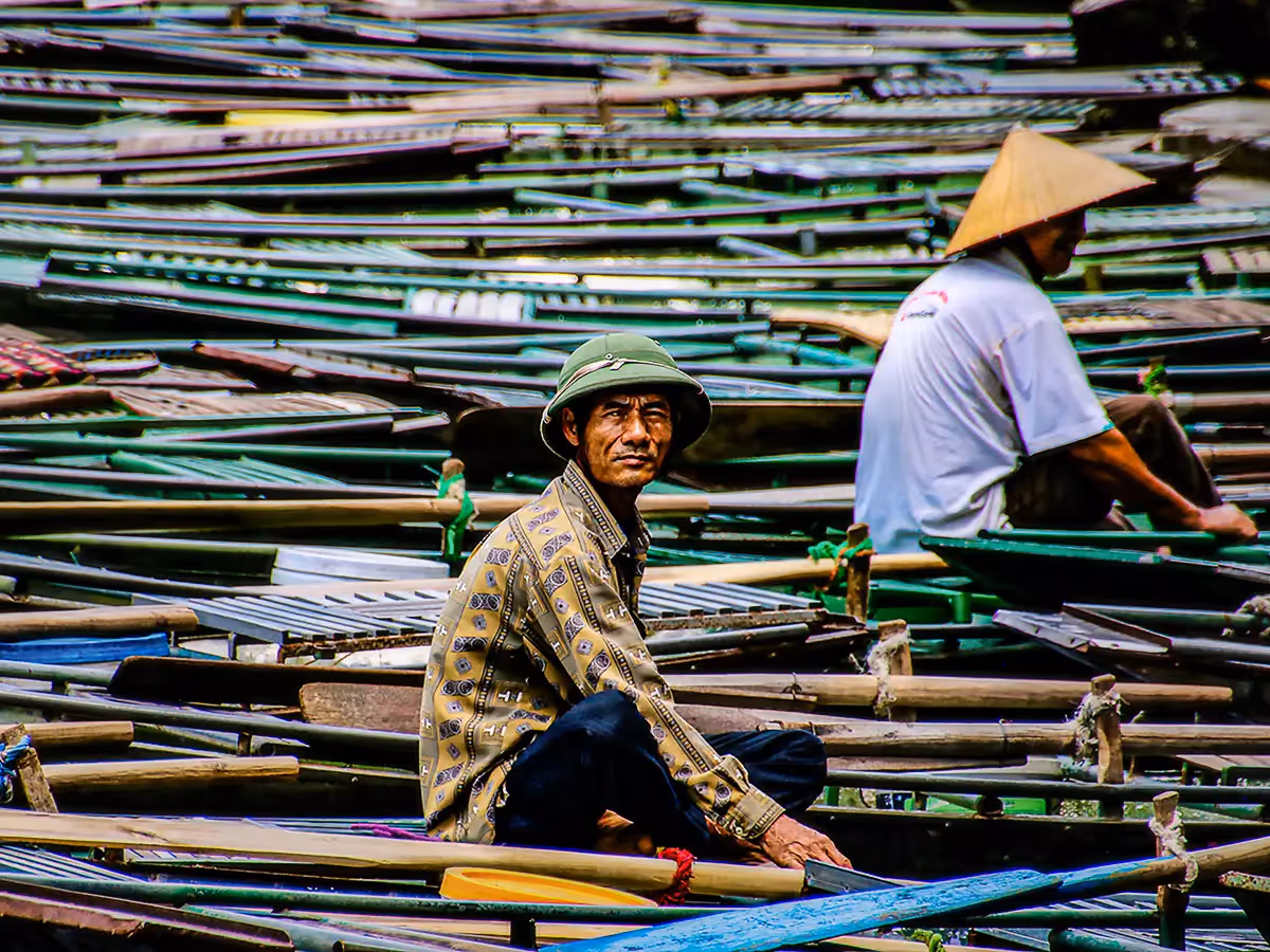 Vietnam: crowded parked canoes with 2 men