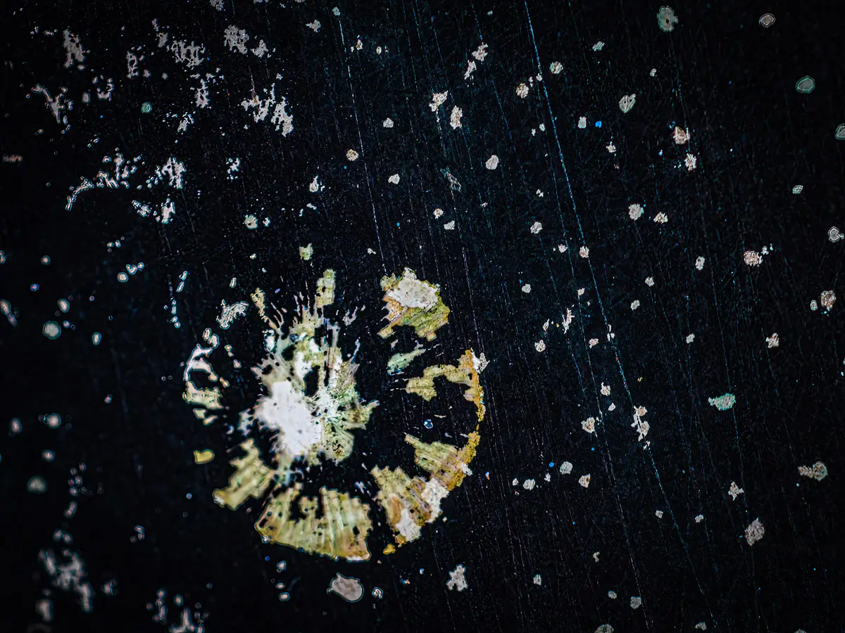 Patterns of rust and barnacles on the hull of a boat out of water.