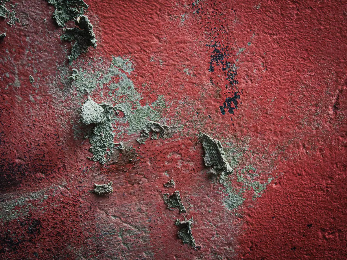 Patterns of rust and barnacles on the hull of a boat out of water.