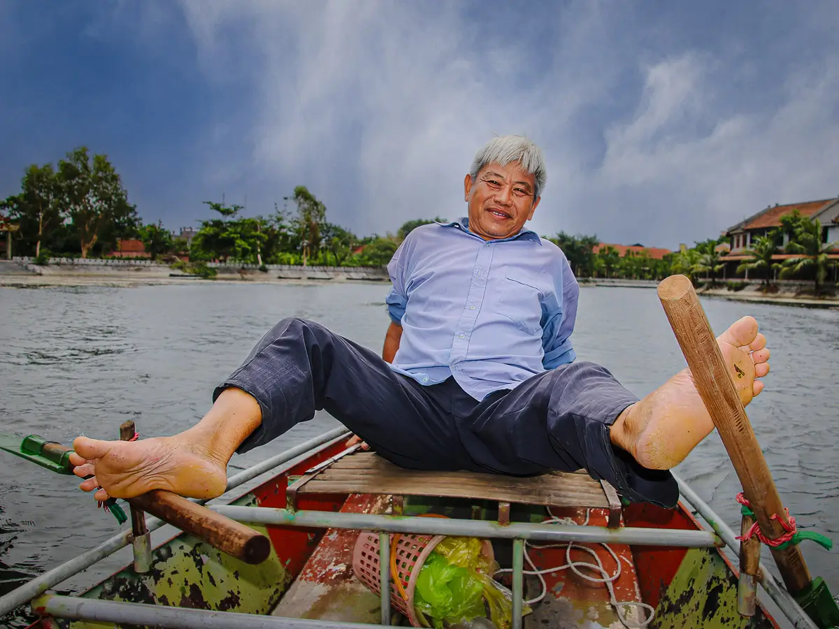 Ninh Binh Vietnam, guide on a boat rowing with his feet.