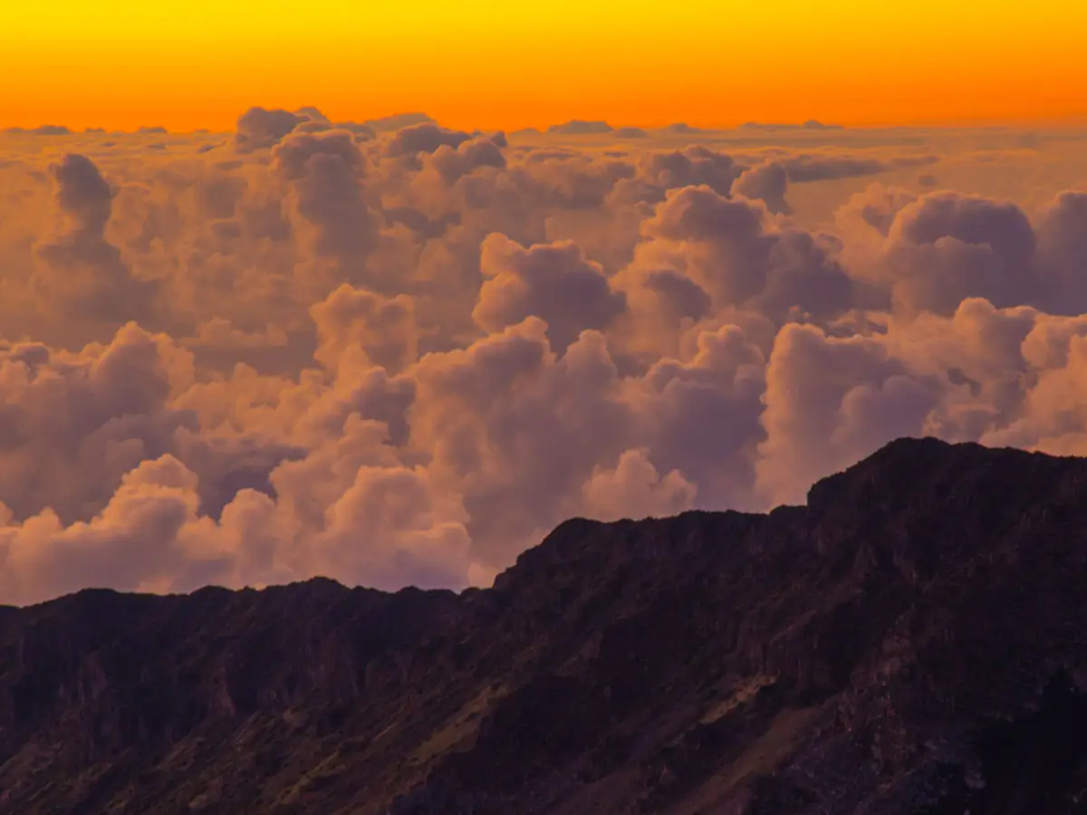 Above the clouds during sunrise on the top of Haleakala volcano in Hawaii