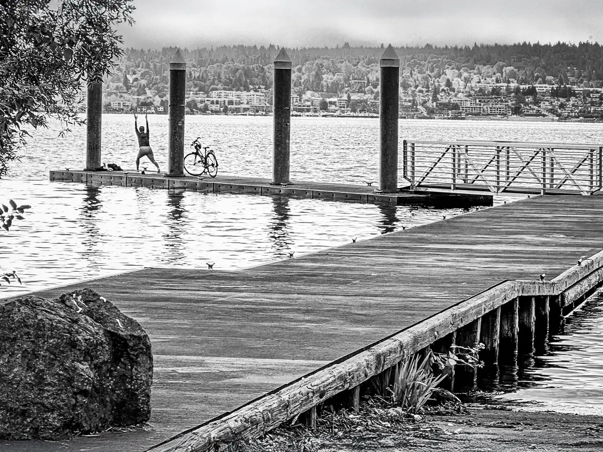 Black and white Mustang going through a car wash with 2 people scrubbing and the water showering down