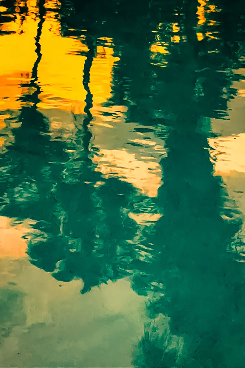 Painterly looking photo showing the moon through a dramatic, dark sky