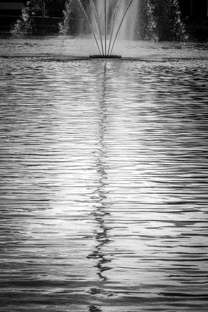 Reflection of a fountain in the water of a pond