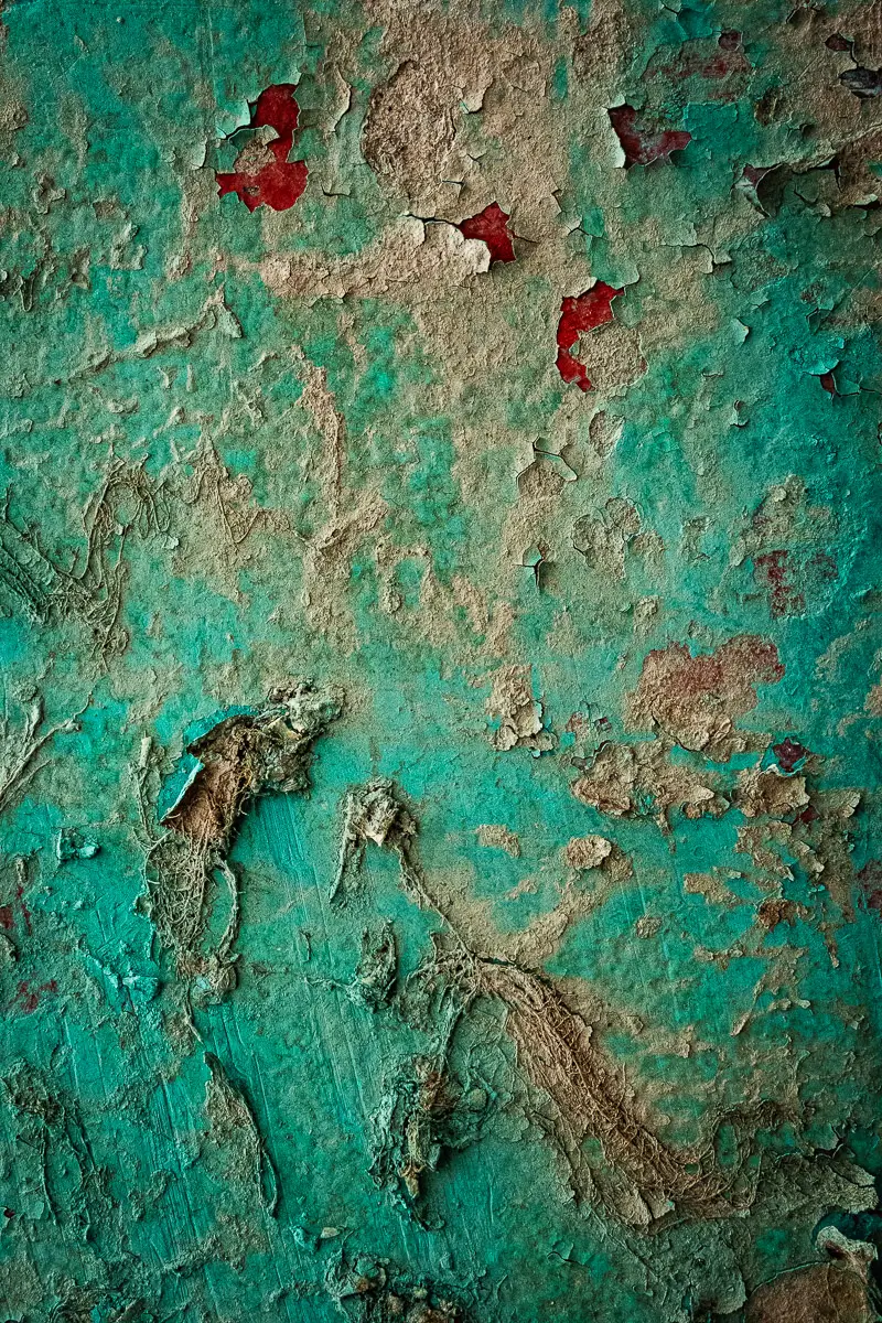 Patterns of rust and barnacles on the hull of a boat out of water.