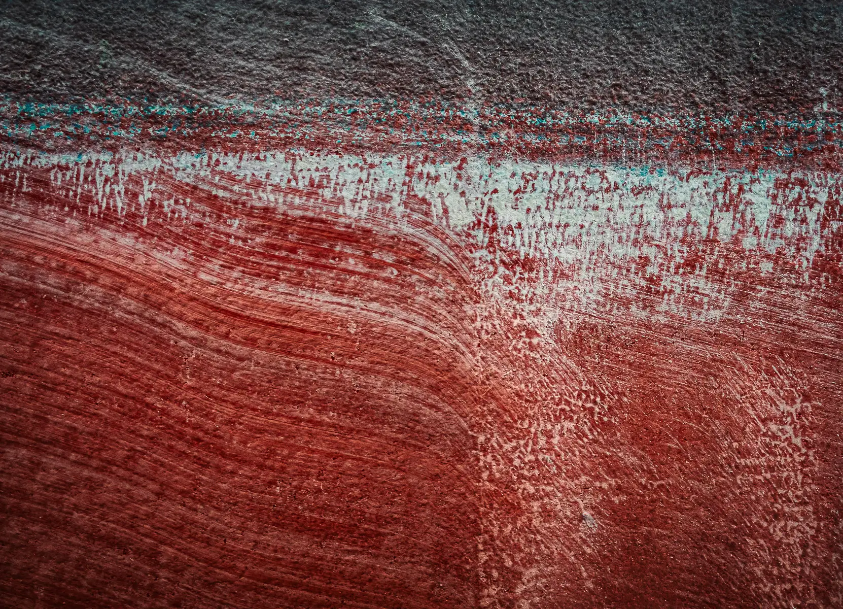 Patterns of rust and barnacles on the hull of a boat out of water.