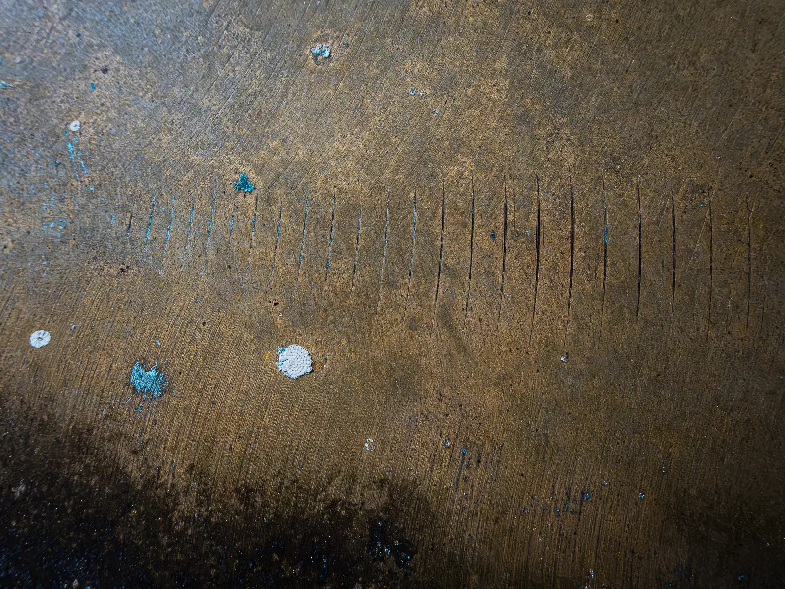 Patterns of rust and barnacles on the hull of a boat out of water.