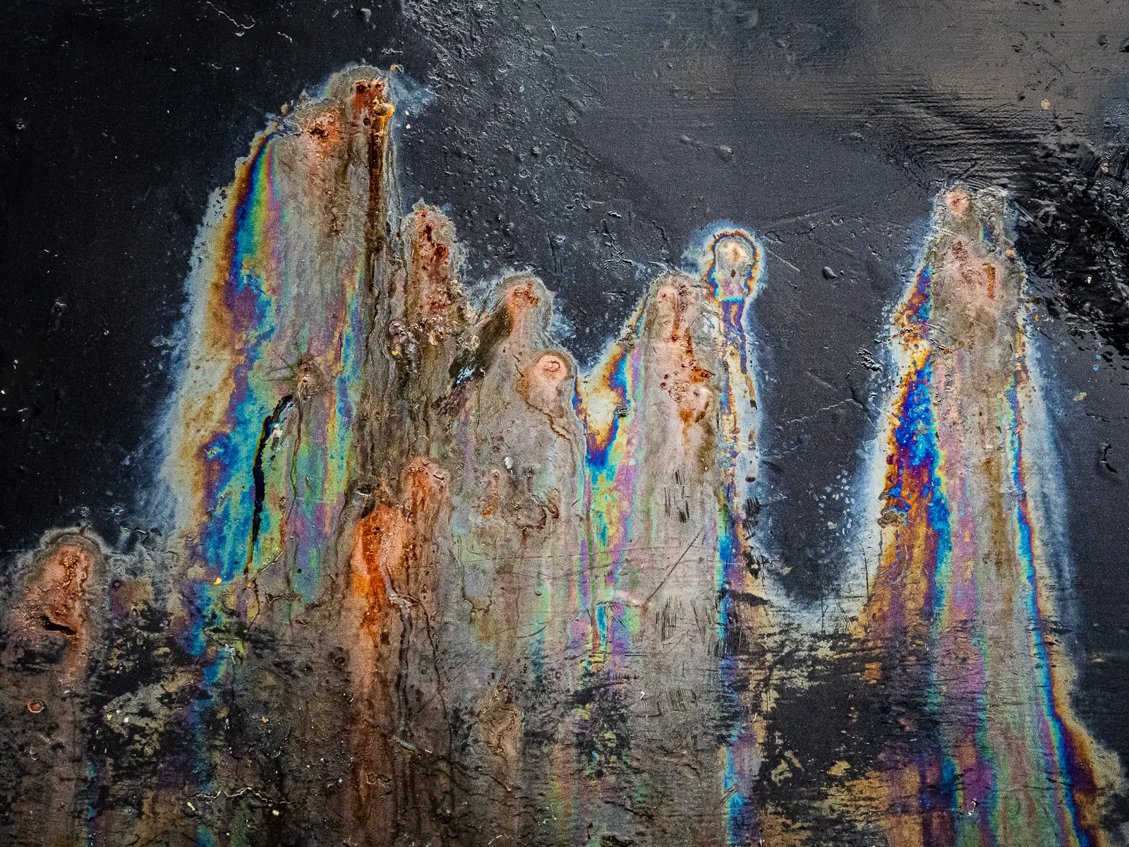 Patterns of rust and barnacles on the hull of a boat out of water.